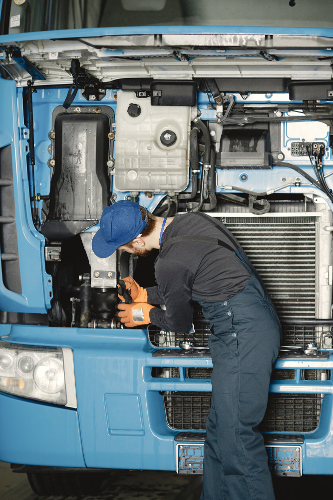 Man with tools for truck. Worker in uniform. Faulty truck Man with tools for truck. Worker in uniform. Faulty truck
